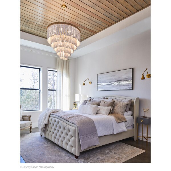 Waterfall chandelier above a gray bed